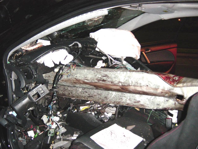 Damaged car interior with deployed airbags and exposed wiring