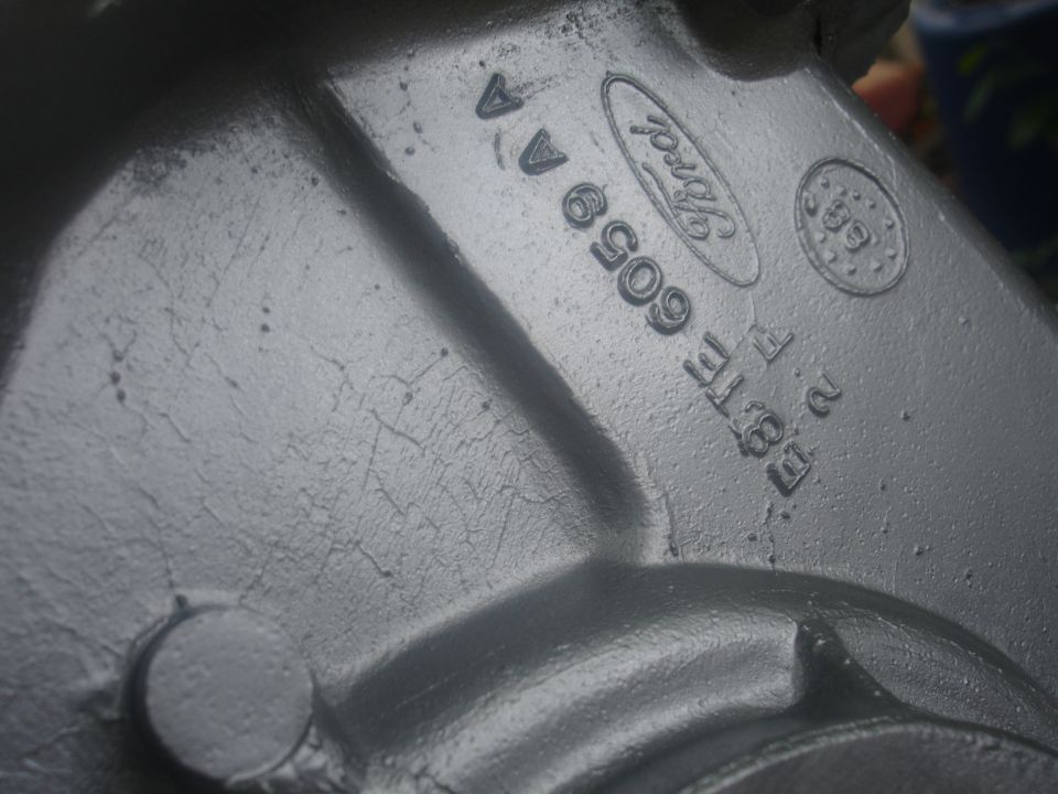 Close-up of a gray metal casting with Ford logo and part numbers.