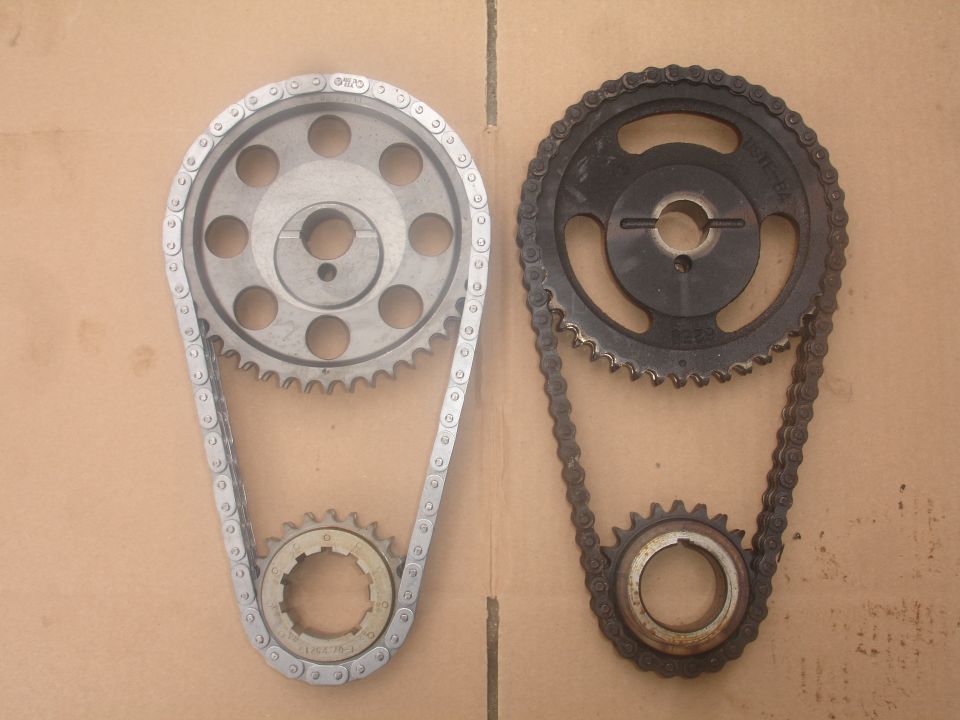 Silver and black timing chain and sprocket sets on cardboard.