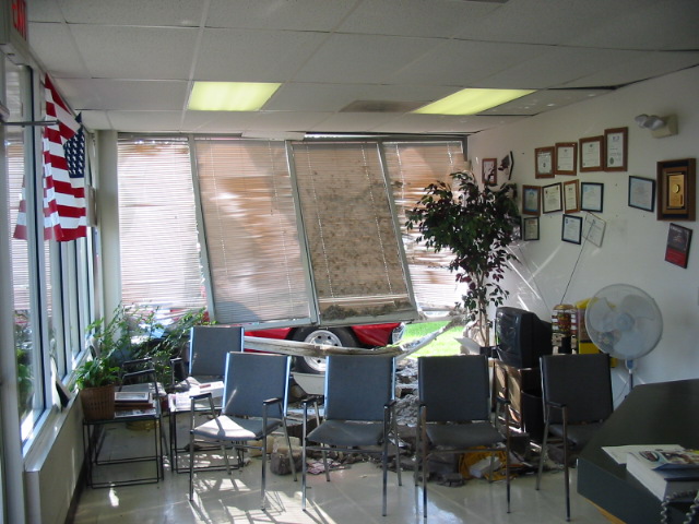 Red trailer with a white tire visible through a broken window