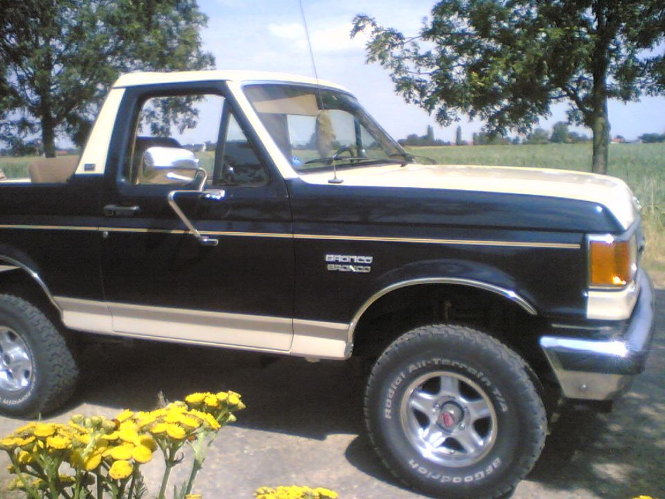 1988 Ford Bronco side view, black and tan exterior, parked outdoors.