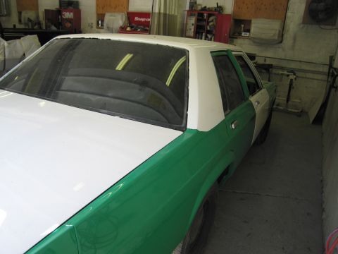 1991 Ford LTD Crown Victoria - Photo of a two-tone sedan side profile in a shop, not a technical document.