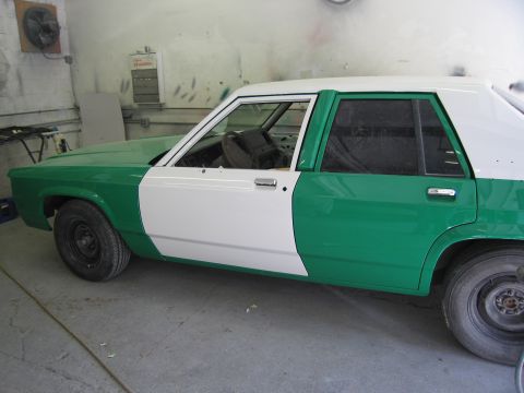 1991 Ford LTD Crown Victoria - Side view of a 1991 Ford Crown Victoria LTD undergoing a two-tone paint job in a workshop.