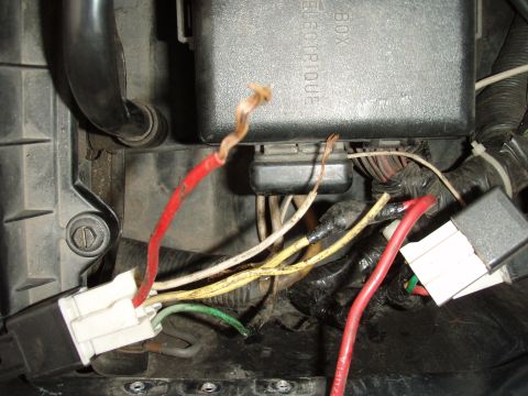 1995 Ford F-150 - Close-up view of automotive electrical wiring and a fuse box, showing various colored wires and connectors.