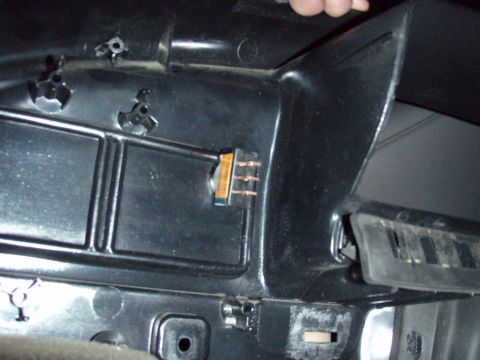 1995 Ford F-150 - Close-up under a vehicle dashboard showing the black plastic HVAC/heater box with a small copper-terminal blower resistor block plugged int…