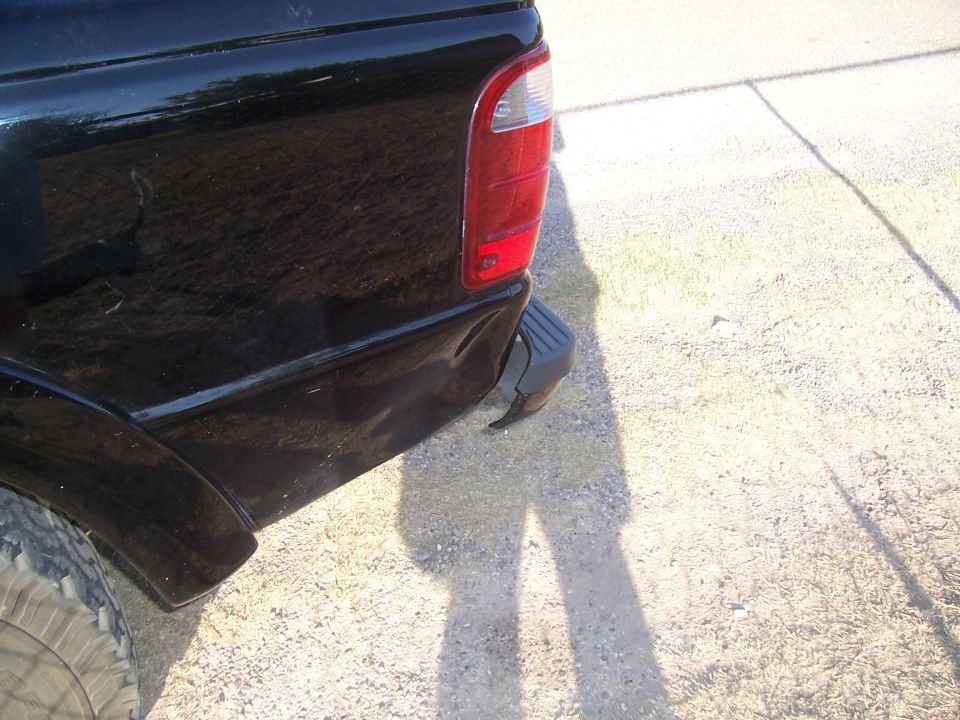 Rear corner of a black 2003 Ford Ranger pickup truck, showing the taillight and bumper