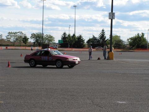 1990 Ford Mustang - This 1990 Ford Mustang coupe is participating in an autocross event, identified by its racing numbers and cones on the track.