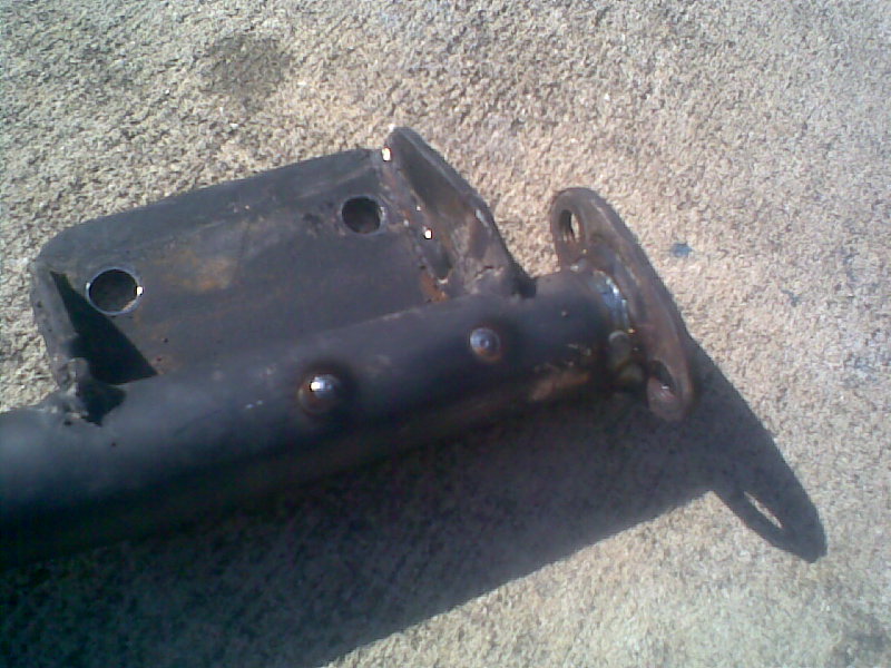 Black metal frame part with welded joints and mounting holes on concrete