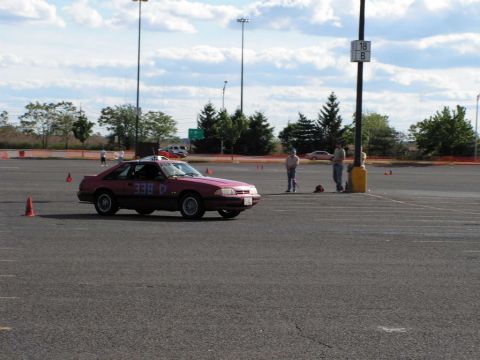 1990 Ford Mustang - A red 1990 Ford Mustang with racing numbers participates in an autocross event.