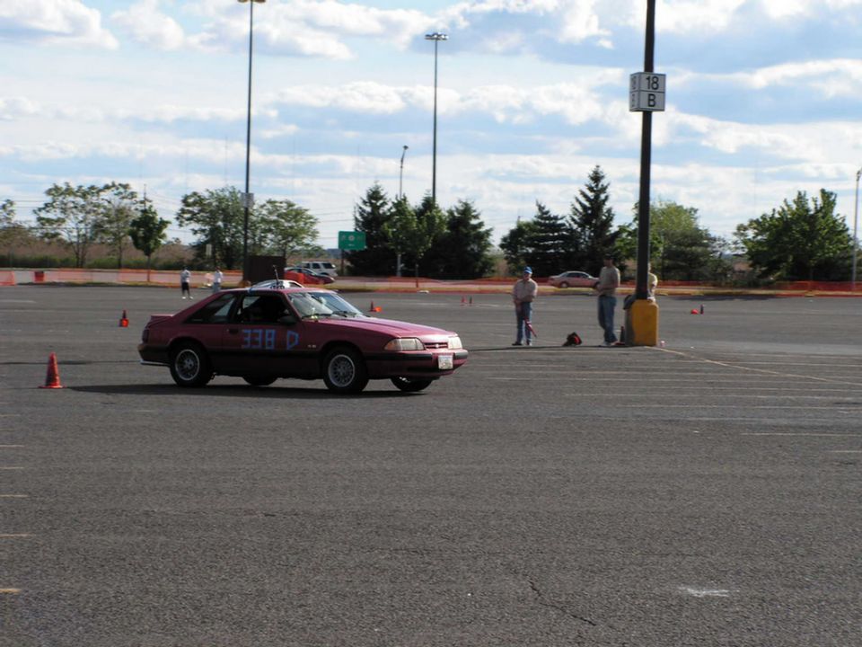 Red coupe with blue racing numbers 338 D on the side, seen from a 3/4 front angle