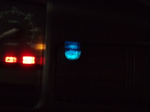 1995 Ford F-150 - Dark night interior shot of a truck dash with a blue-illuminated rocker switch glowing in the switch panel to the right of the instrument c…