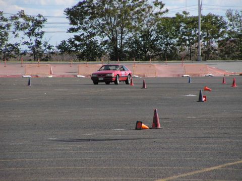 1990 Ford Mustang - A red 1990 Ford Mustang navigates an autocross course marked by traffic cones.