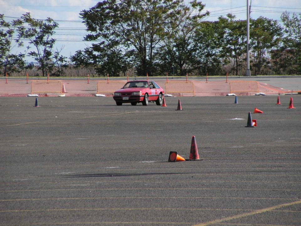 Red 1990 Ford Mustang on autocross course