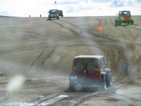 1994 Ford Bronco - Off-road vehicles navigate sandy terrain with flags marking their presence.