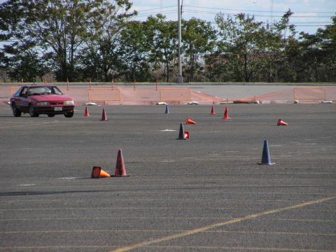 1990 Ford Mustang - A red 1990 Ford Mustang navigates an autocross course marked by traffic cones.