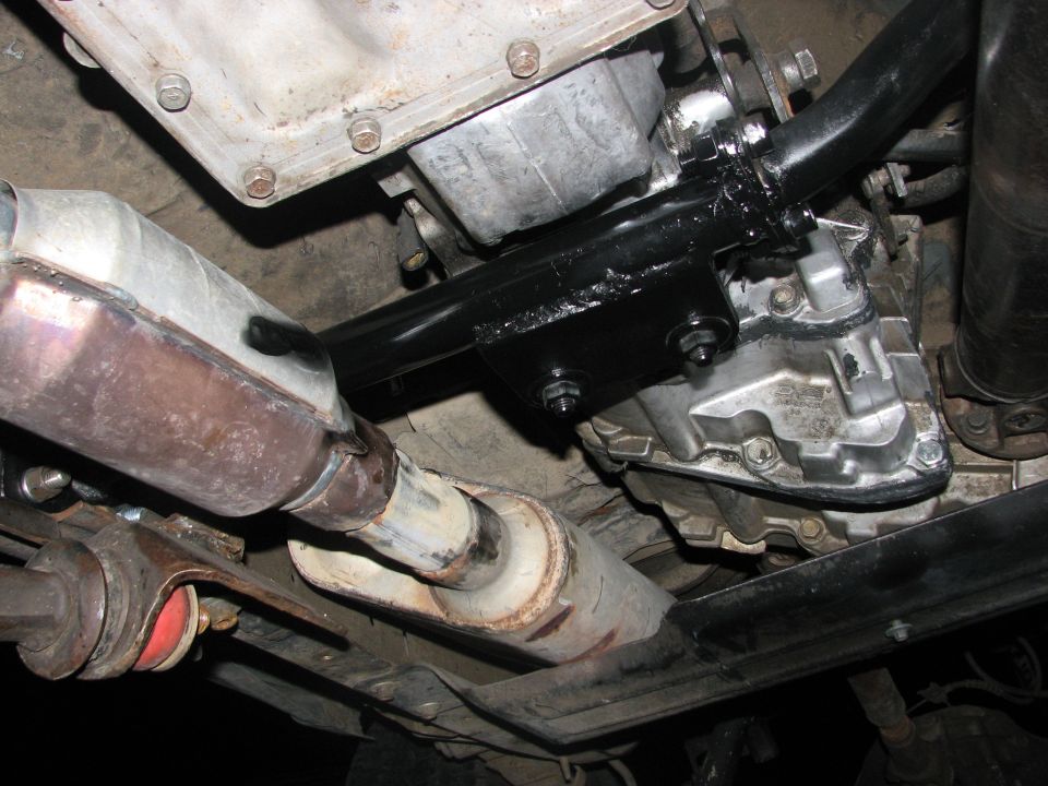 Underside view of vehicle transmission, exhaust pipe, and crossmember