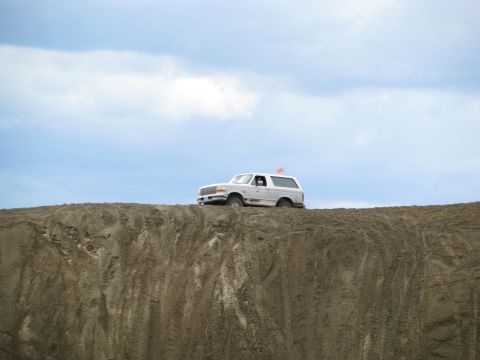 1994 Ford Bronco - SUV parked on a sand dune with a red flag visible on its roof.