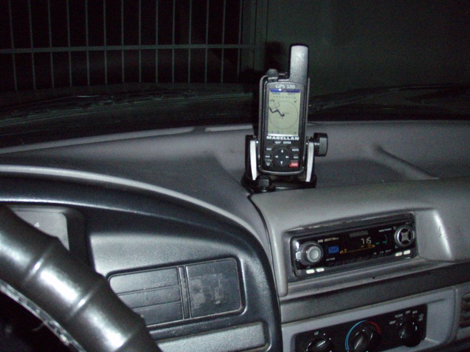 Magellan handheld GPS unit mounted on truck dash above aftermarket stereo