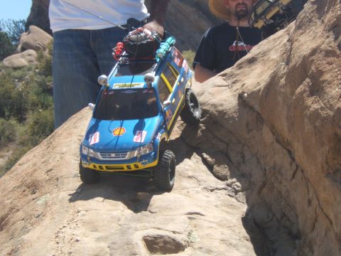 1988 Ford Bronco - A remote control SUV navigates a rocky terrain, with people in the background.