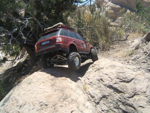 1988 Ford Bronco - This remote-controlled vehicle navigates a rocky, off-road terrain under a clear sky.