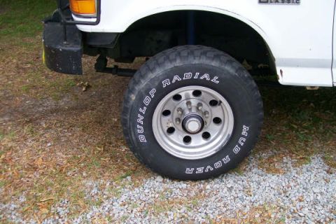 1992 Ford C-350 (Centurion Conversions) - Close-up of a truck's front wheel and fender, showing the tire tread and wheel details.