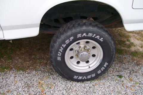 1992 Ford C-350 (Centurion Conversions) - Close-up of a large tire on a white pickup truck, showing the tread and wheel.