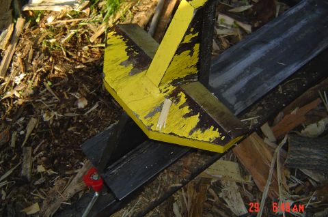 1946 Ford F1 - A yellow splitter part is mounted on a black metal frame, surrounded by debris.