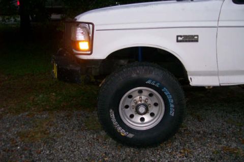 1992 Ford C-350 (Centurion Conversions) - Close-up of a white Ford truck's front fender and tire, with a 'C350' badge visible.