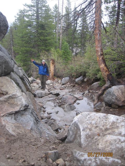 1994 Ford Bronco - A person stands on a rocky path in a forest, with puddles and trees surrounding them. The date 05/27/2008 is visible.