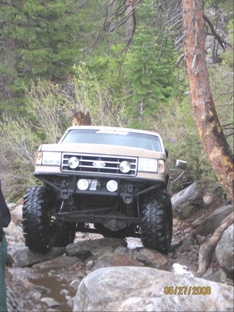 1994 Ford Bronco - This modified Ford Bronco is shown tackling a difficult rocky trail, demonstrating its off-road capabilities.