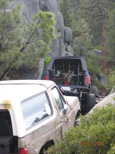 1994 Ford Bronco - Two SUVs navigate a challenging rocky trail, with one clearly identifiable as a 1994 Ford Bronco.