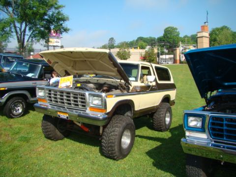 1994 Ford Bronco - A classic Ford Bronco is displayed with its hood up at an outdoor event.