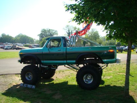 1994 Ford Bronco - This heavily modified pickup truck features oversized tires, a tall lift, and a prominent dual exhaust system.