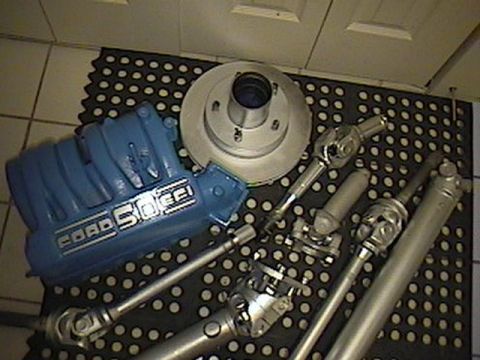 1992 Ford Bronco - Ford Bronco intake manifold and driveshaft parts laid out on a mat.