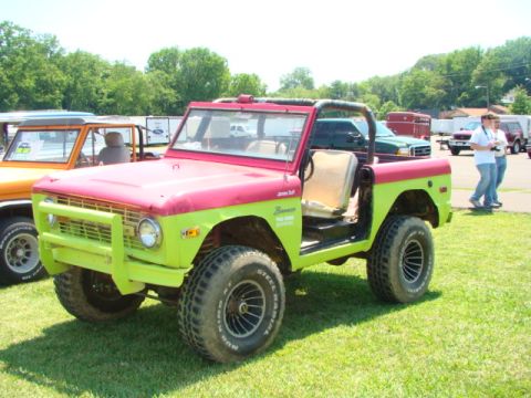 1994 Ford Bronco - This two-tone Ford Bronco is parked on grass with other vehicles in the background.