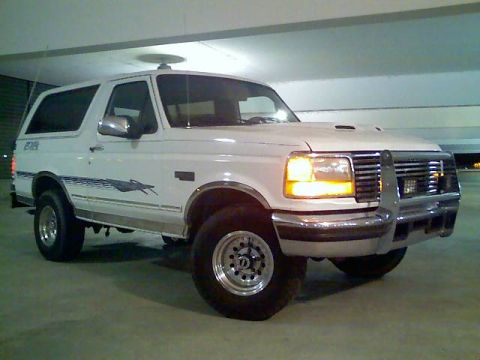 1996 Ford Bronco - A white 1996 Ford Bronco is shown from a three-quarter front angle in a parking garage.