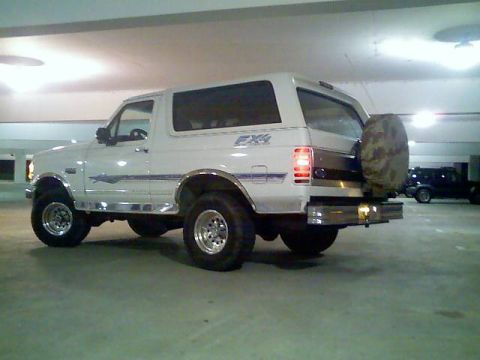 1996 Ford Bronco - This 1996 Ford Bronco is parked in a garage, showing its rear 3/4 profile with aftermarket modifications.