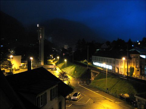 1996 Ford Bronco - A street scene at night shows a parked silver car and other vehicles in the distance.