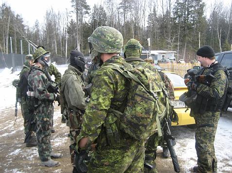 1985 Ford Bronco - People in camouflage gear gather outdoors, with a yellow car visible in the background.