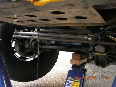 1996 Ford Bronco - Undercarriage view of a vehicle's suspension and differential, supported by a hydraulic jack.