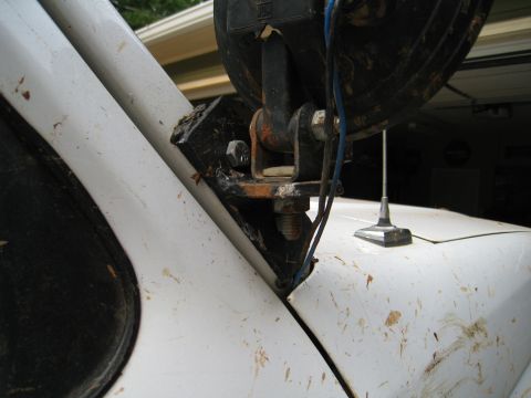 1996 Ford Bronco - Close-up of a custom off-road light mount attached to the fender of a white vehicle.