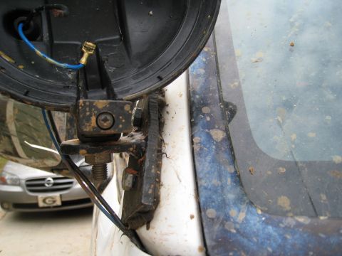 1996 Ford Bronco - Aftermarket auxiliary light mount on a dirty vehicle, with another car in the background.