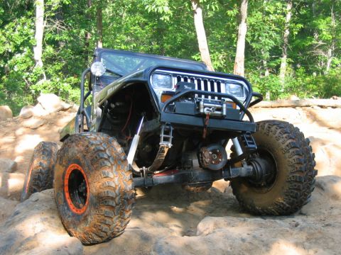1992 Ford Mustang - This heavily modified Jeep Wrangler is navigating a challenging rocky trail.