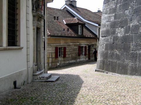 1996 Ford Bronco - A narrow street in a historic European town features stone buildings and a cobblestone pavement.
