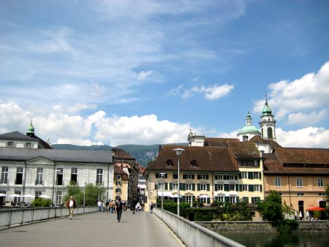 1996 Ford Bronco - A view across a bridge in a European town, with historic architecture and a river below.