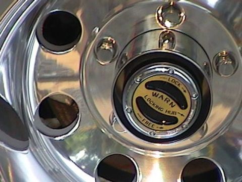 1992 Ford Bronco - Close-up of a Warn locking hub on a shiny chrome wheel.