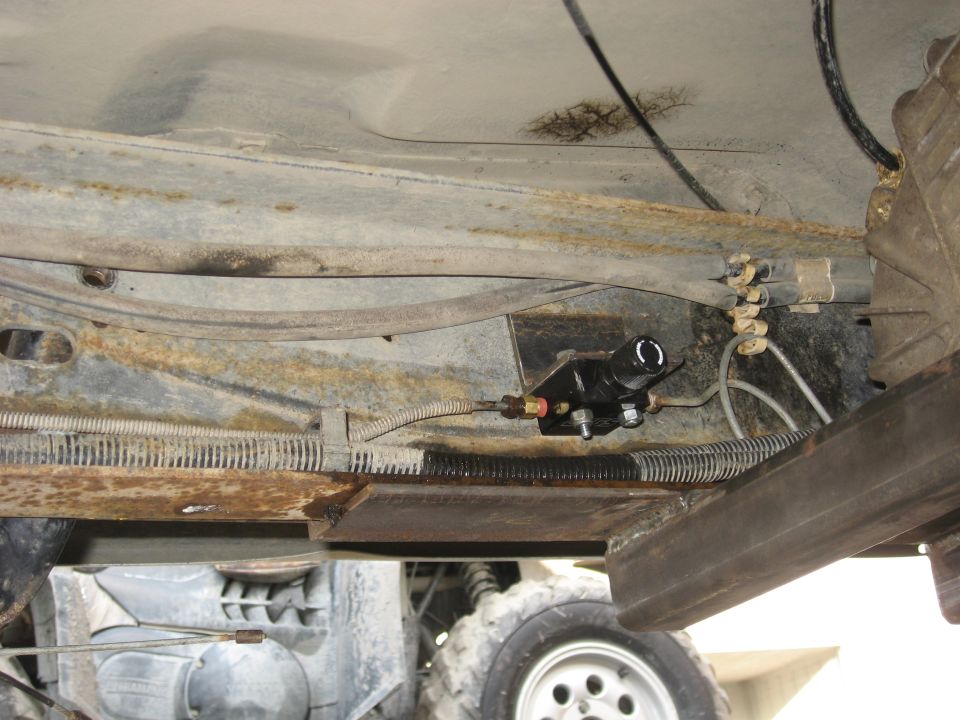 Underbody view of a vehicle floor pan with a fuel filter and lines