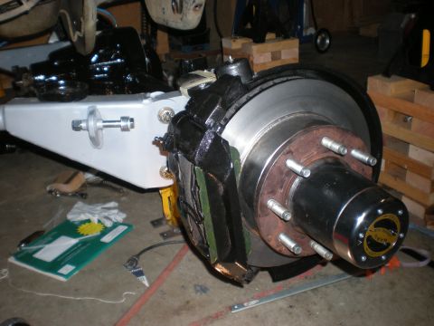 1993 Ford Bronco - Close-up of a vehicle's front axle assembly, showing brake components and suspension linkage.