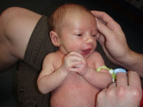 1997 Ford F-250 - A newborn baby is being held by adults, with a yellow band on its arm.