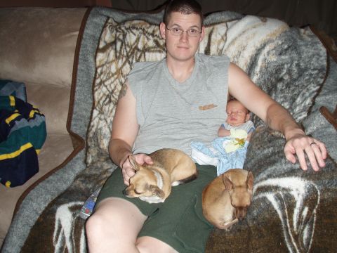 1997 Ford F-250 - A man relaxes on a couch with his baby and two dogs, covered by a patterned blanket.